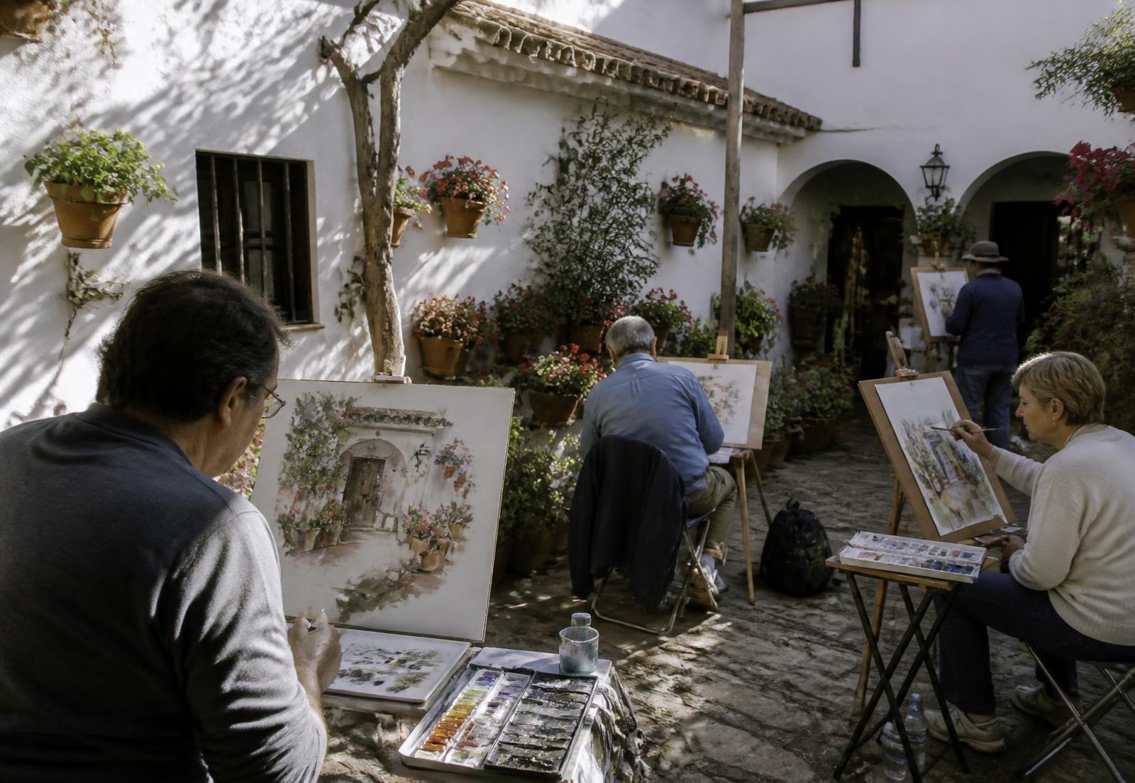 Acuarelistas pintando en un patio cordobés bajo la luz de la tarde